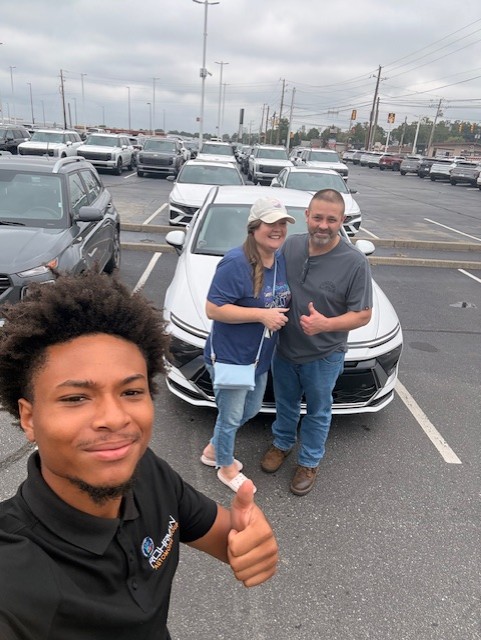 Damarion with two customers and their newly purchased vehicle